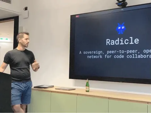 Kostis mid-talk at ViennaJS beside his title slide, “Radicle: a sovereign, peer-to-peer, open-source network for code collaboration”, 5 June 2024